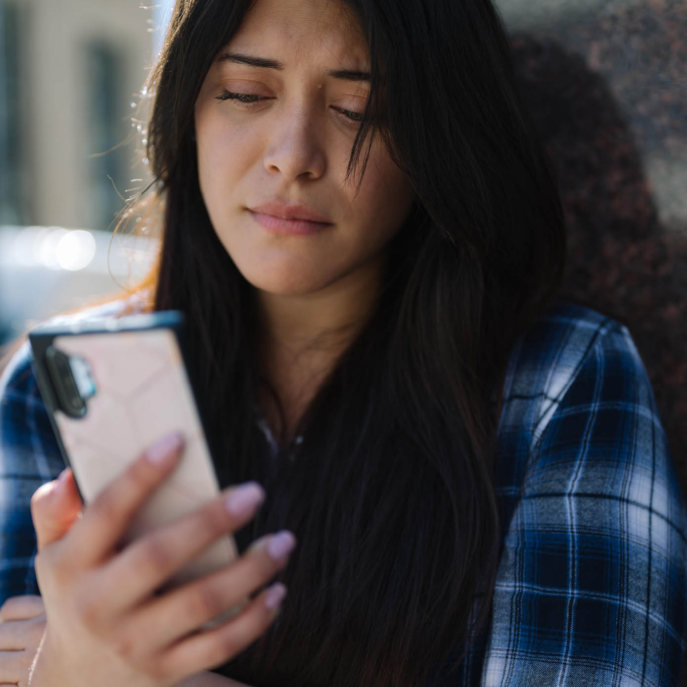 woman looking at phone with a look of concern