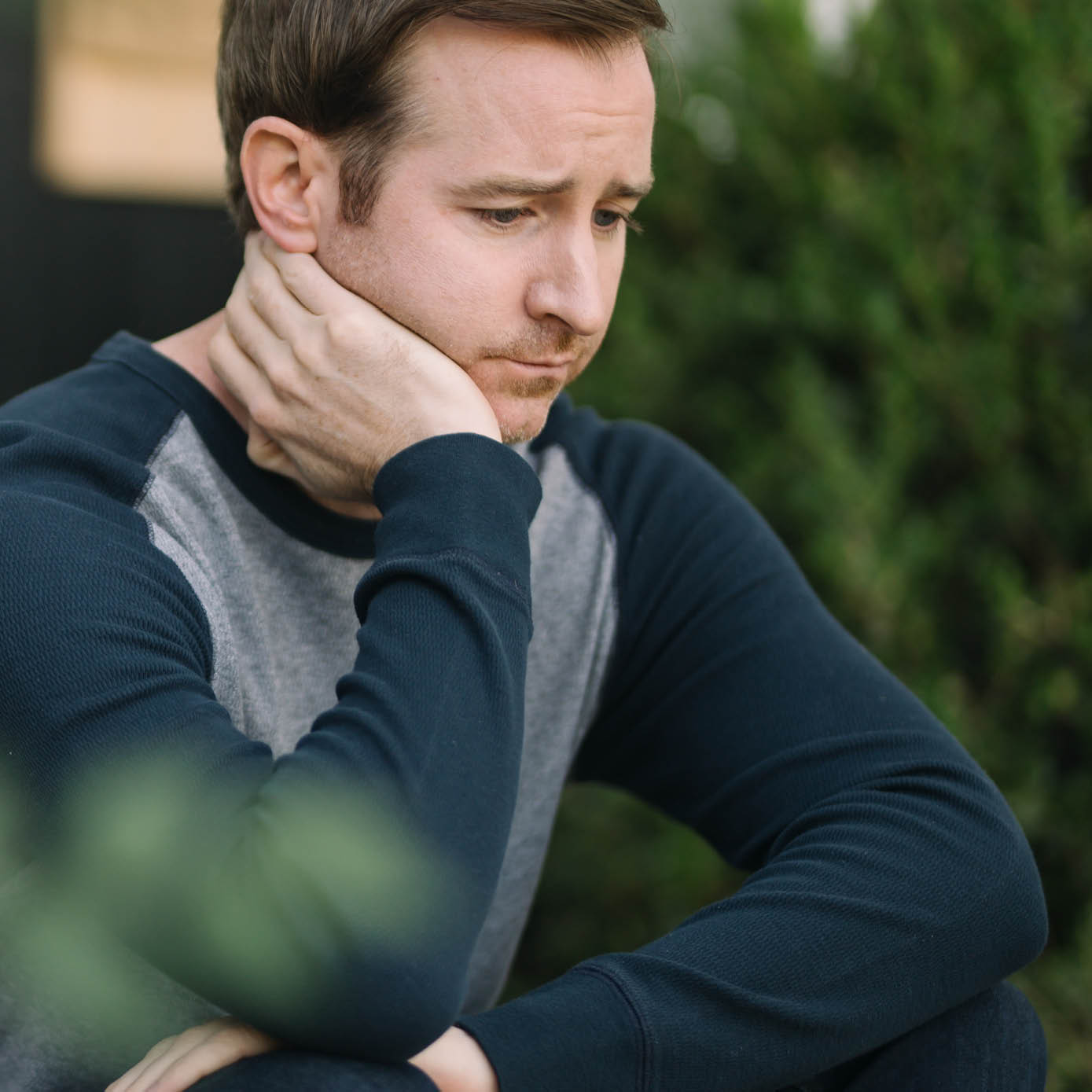 White man wearing blue shirt looking concerned.