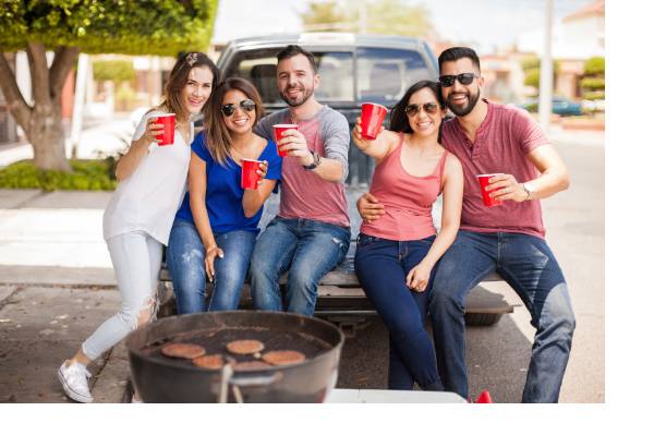 Group of young people holding red cups at a tailgate party