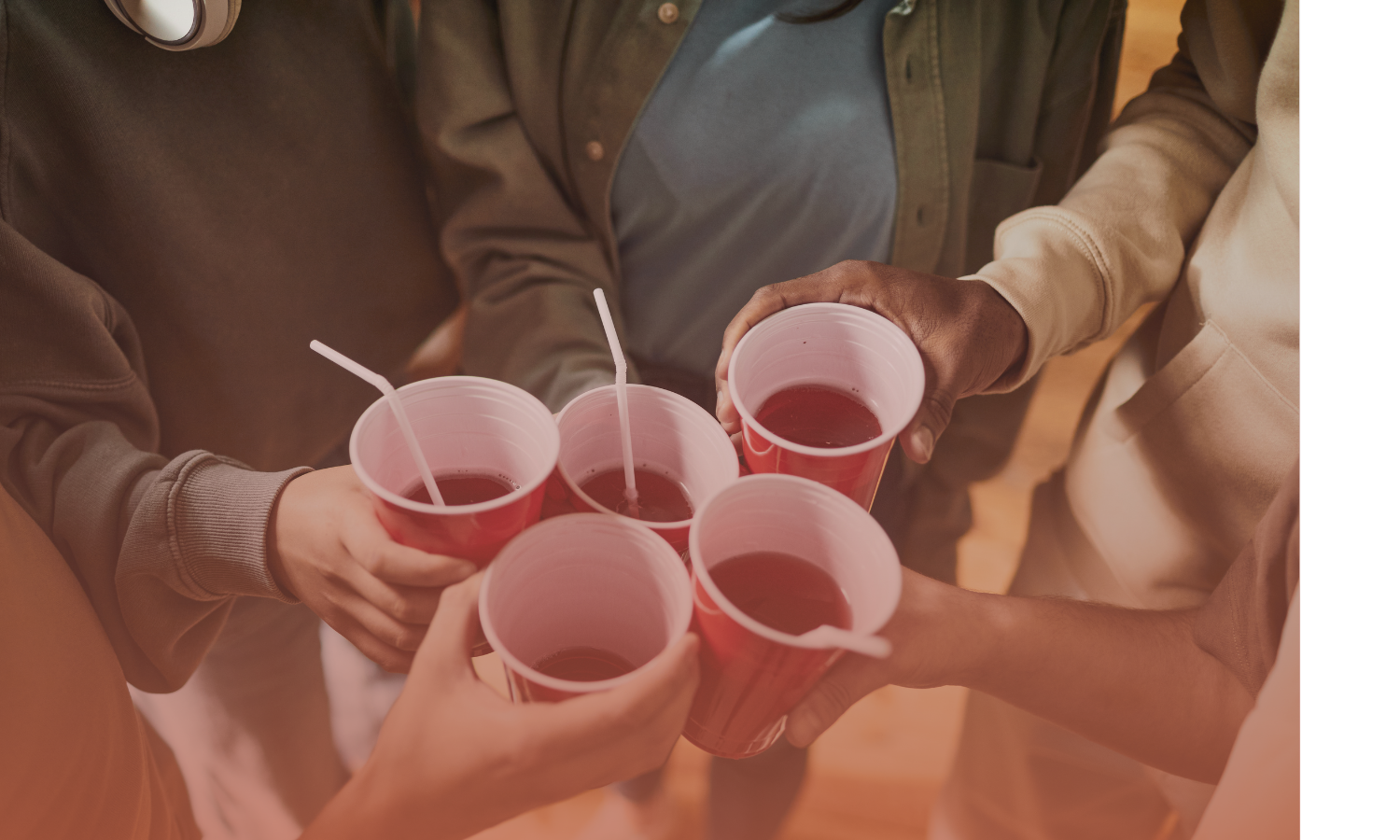 Group of people holding red plastic cups of red liquid