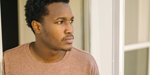 Man standing outside door with serious expression