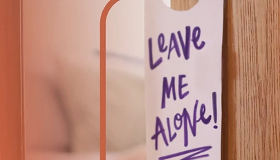 close-up of a handwritten door knob sign that reads "Leave Me Alone!"