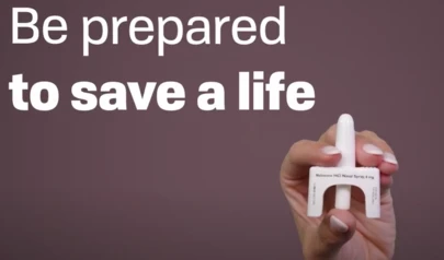 a hand holding a Naloxone applicator