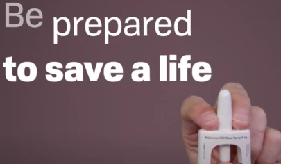 a hand holding a Naloxone applicator