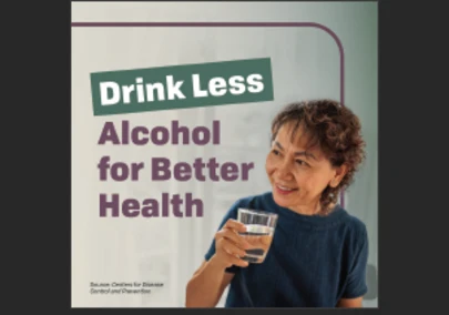 an older woman smiling and holding a glass of water