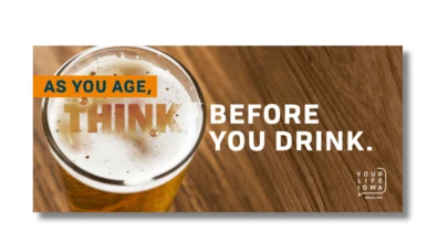 a glass of beer on a wood surface with campaign text