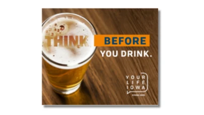 a glass of beer on a wood surface with campaign text