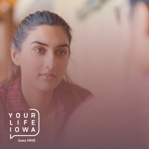 Woman in her 20s looking concerned while talking to another person.