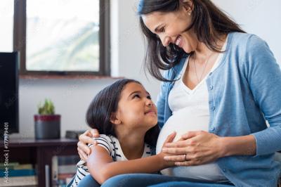 Pregnant mom rubbing belly with daughter