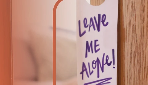 close-up of a handwritten door knob sign that reads "Leave Me Alone!"