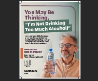 a man smiling and holding a water bottle