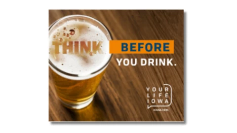 a glass of beer on a wood surface with campaign text
