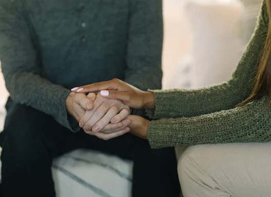Two people holding hands supporting one another
