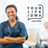 Woman wearing scrubs and a stethoscope standing and smiling
