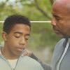 A man places his arm on a teen's shoulder