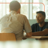 Young man and teen talking at a table