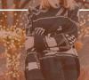 A woman wearing a sweater holds her arm