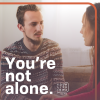 White adult man in his 20s talking to a female friend, looking concerned.